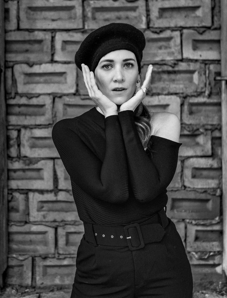 Editorial portrait wearing a beret, hands framing the face